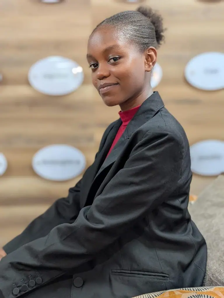 Professional portrait of Michelle Mugo in a black suit
